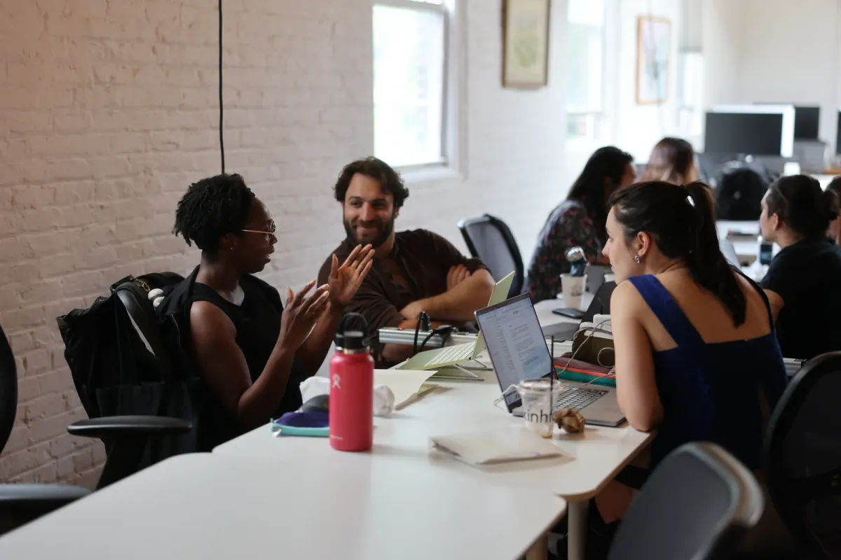 Participants talking and working together around a table at Fractal Campus
